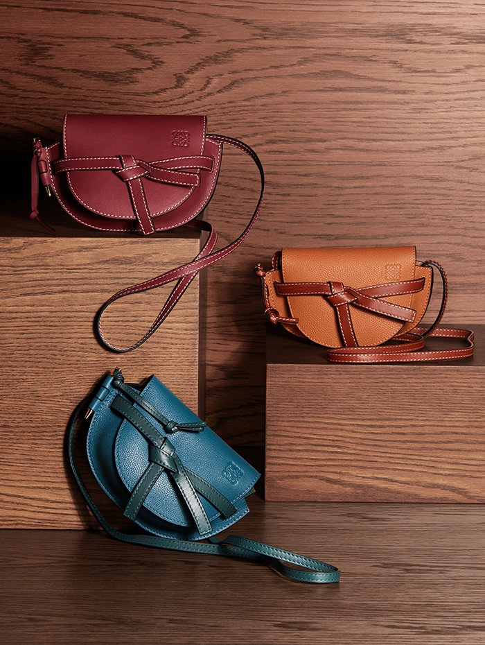Holt Renfrew Image of LOEWE smooth leather Gate Mini crossbody in wine. $1590. Grained leather Gate Mini crossbody in petroleum blue and Cypress, or light caramel and pecan. $1550 each.