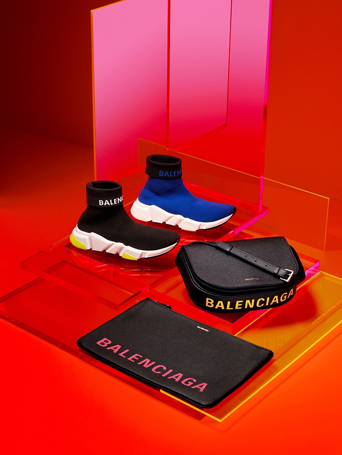 Holt Renfrew image of Balenciaga Fabric Speed sneaker with logo. $1065 each. Ville pouch in noir and rose. $1035. Ville messenger bag with flap in bleu tempette and jaune. $2065. Both in leather with logo.