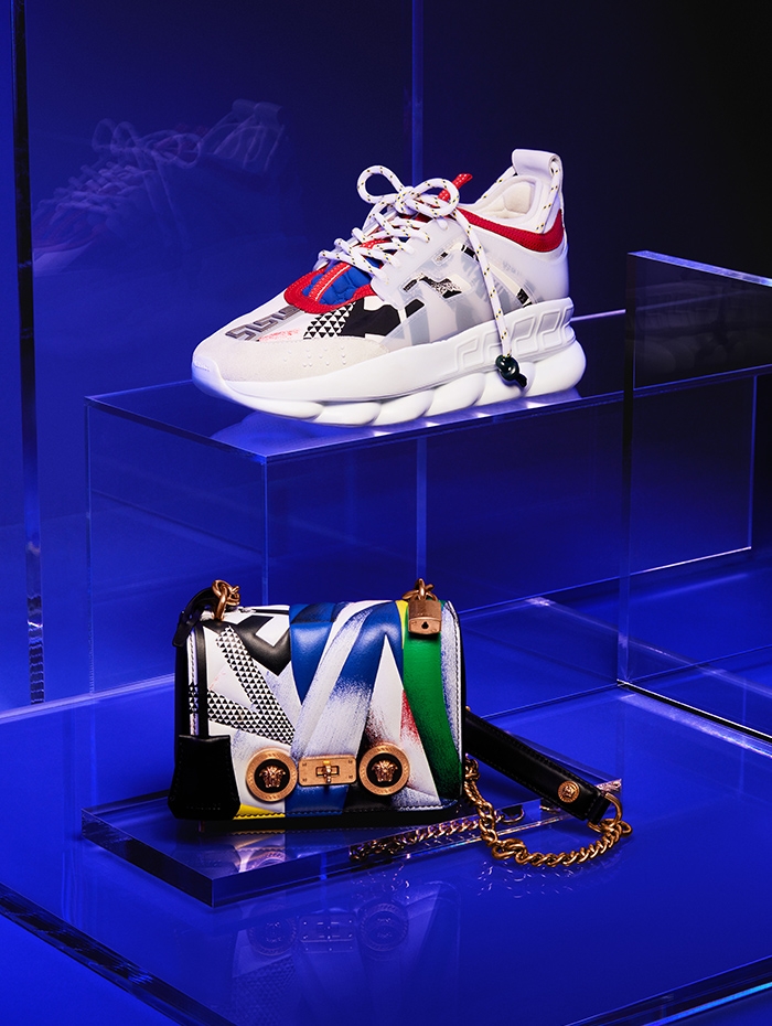 Holt Renfrew image of Versace Leather Chain Reaction sneaker. $1225. Leather Icon mini shoulder bag in Clash print. $2700.