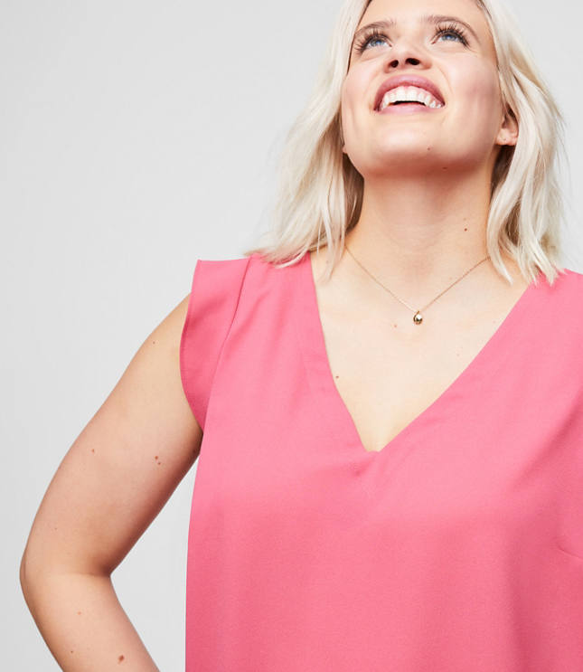 Engineered with stretch-effect fabric for maximum comfort and movement, flutter sleeves are a femme finish for this oh-so-polished and fluid shell. V-neck. Flutter cap sleeves. Shirred beneath back yoke. Shirttail hem.