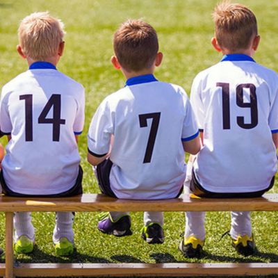 young boys from soccer team sitting on bench