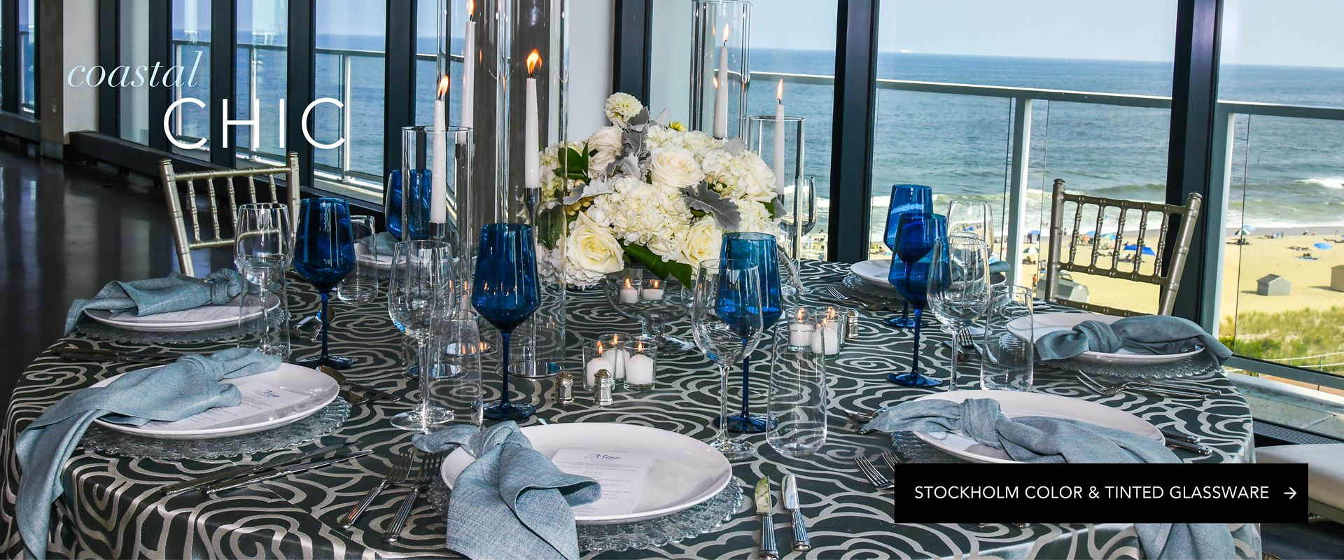Coastal chic event design with cobalt blue glassware available for rent at a seaside venue.
