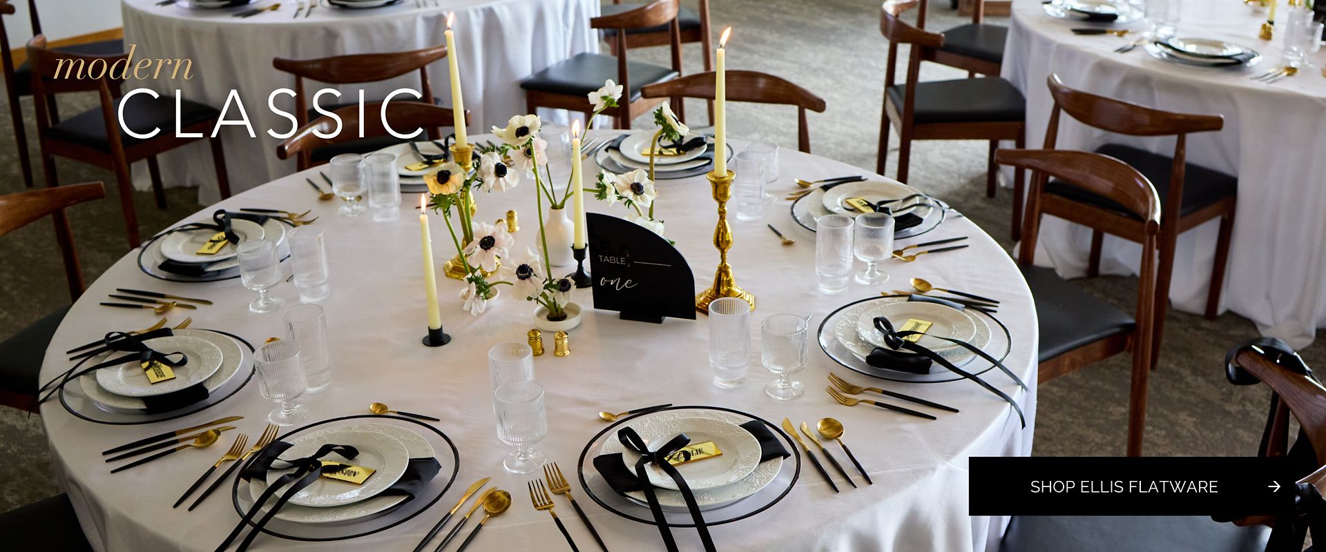 Sophisticated table setting featuring Ellis gold and black flatware and black ribbon accents