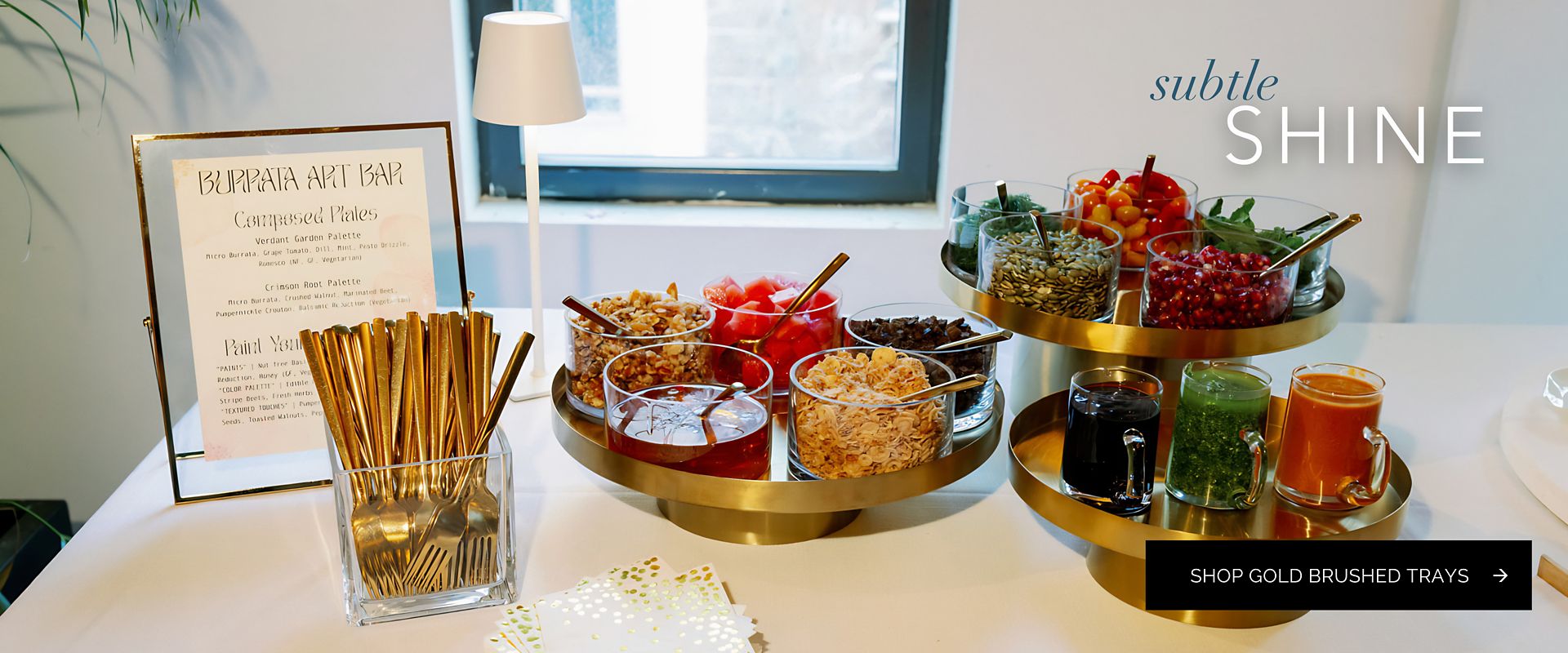 Gold brushed trays showcasing a variety of gourmet ingredients and toppings at a Burrata Art Bar
