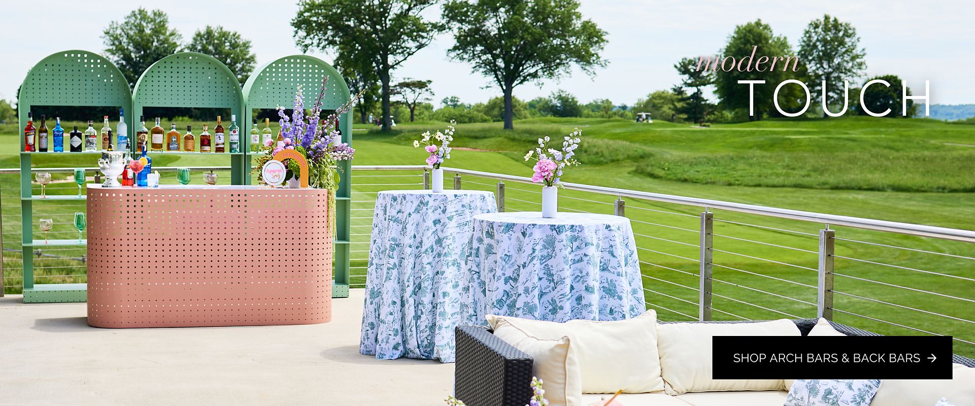 Modern green arch bars and a peach-colored bar unit set up outdoors as a stylish drink display.