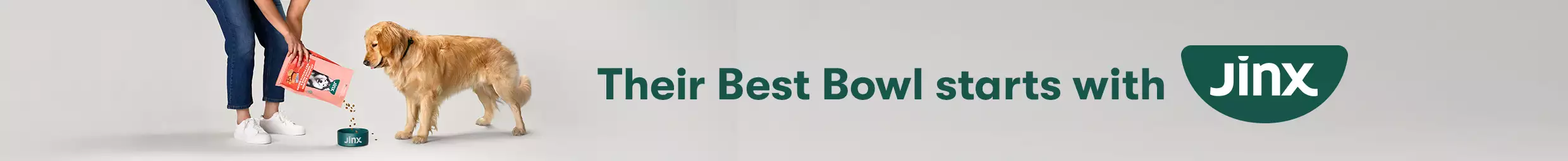 Dog being fed Jinx dog food with text "Their best bowl starts with Jinx"