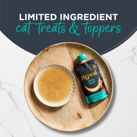 Image of Reveal Tuna Flavored Bone Broth pack and bowl of broth on a wooden plate