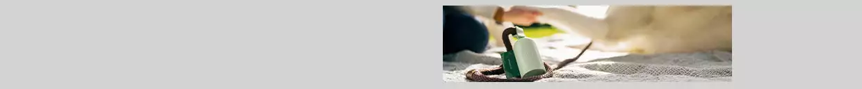 picture of an earth rated poop bag holder with bags in it on the ground