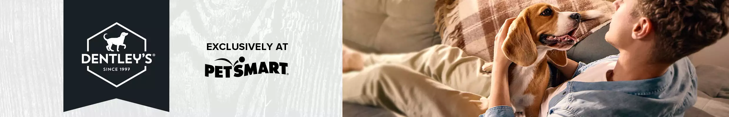 Dentley's logo, exclusively at PetSmart. Pet parent with their dog on the couch.
