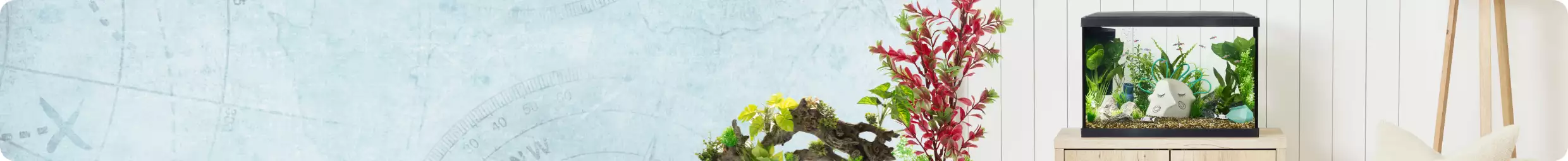 Aquarium filled with fish and decor on right, live plants on left, with Fish Ornaments text on far left over blue treasure map background