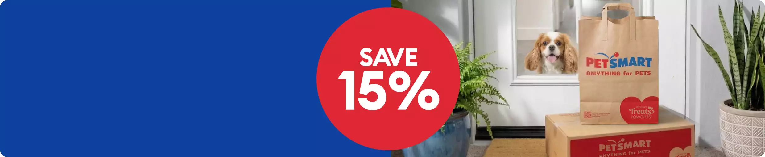 Save 15% callout and a brown-and-white dog sitting at a front-door window looking at a PetSmart bag and box that was delivered.