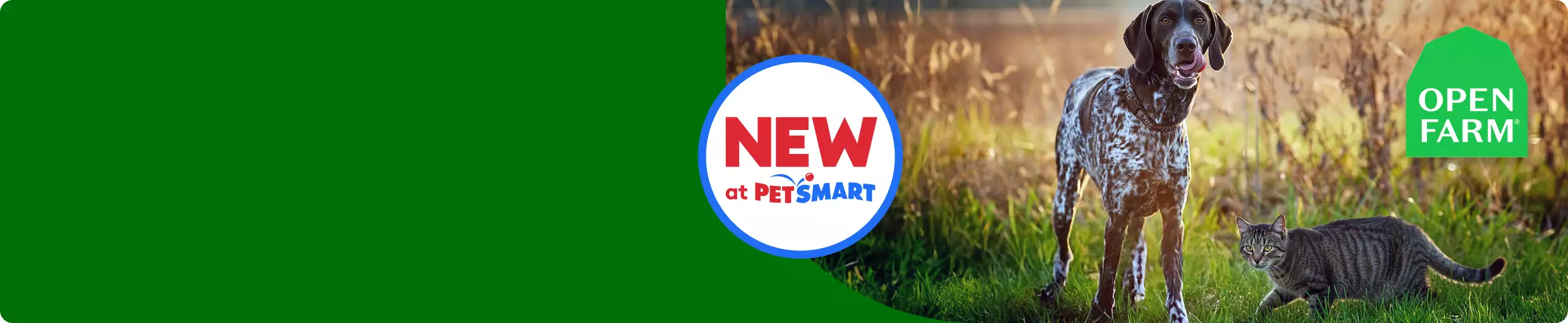 Dog & cat standing outside in a grassy field with a NEW at PetSmart badge & a green Open Farm logo