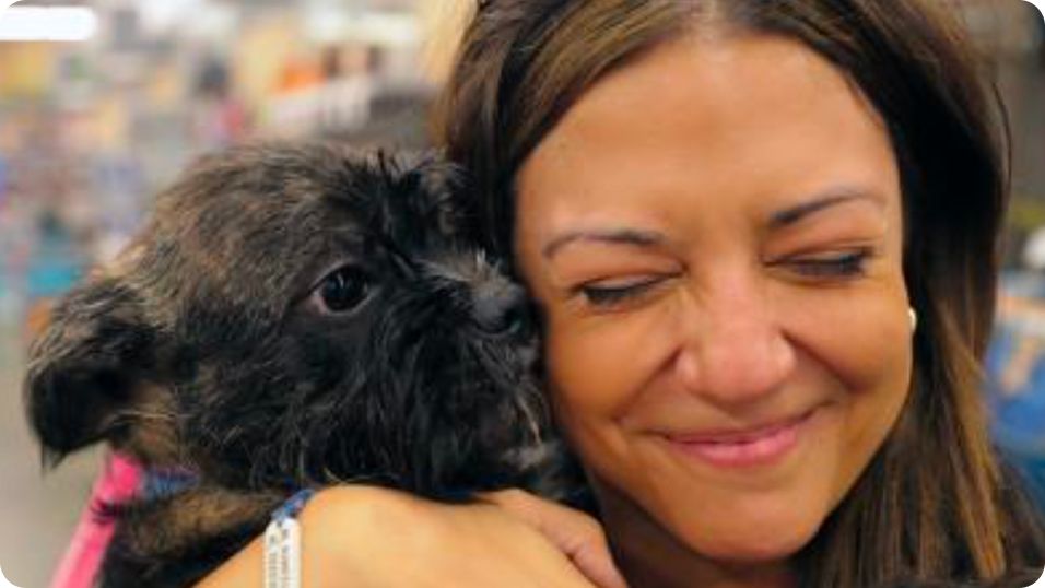 Woman holding a black dog