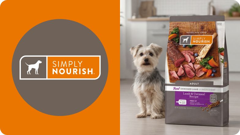 Simply Nourish logo & a small dog sitting beside a bag of food in a kitchen
