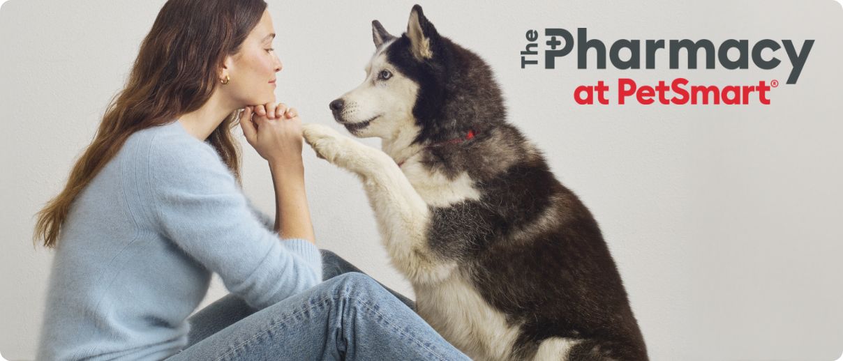 The Pharmacy at PetSmart logo and a woman sitting with her dog on the floor and the Pharmacy at PetSmart logo