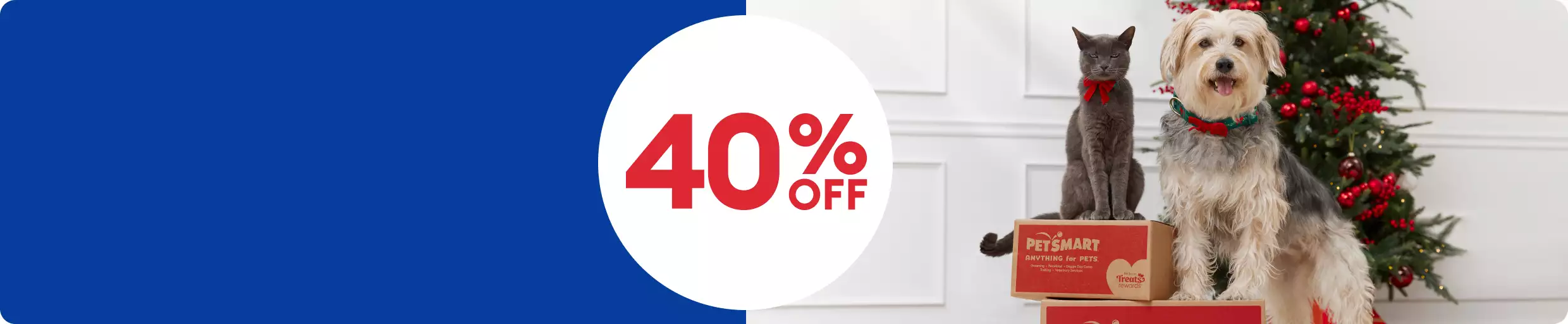 40% off text in a white circle and a cat & dog standing on PetSmart shipping boxes in front of a Christmas tree		