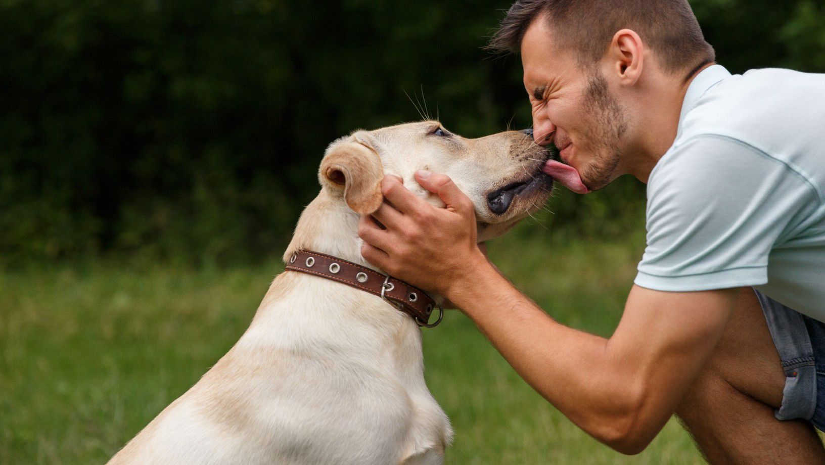 Pet dad and his dog licking his face