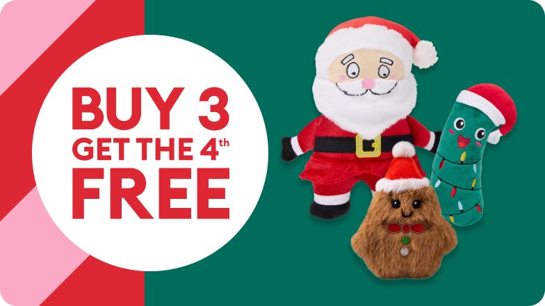 Various holiday dog toys including a Christmas pickle and Santa on a green background