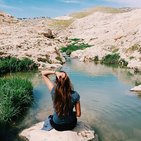 A photo captured with Galaxy by Instagram user @shovali123 of a girl sitting on a rock in front of a small waterway and rocky hills