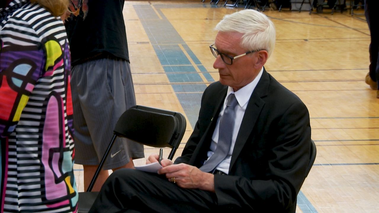 Gov. Evers takes notes at last statewide budget listening session in Milwaukee.