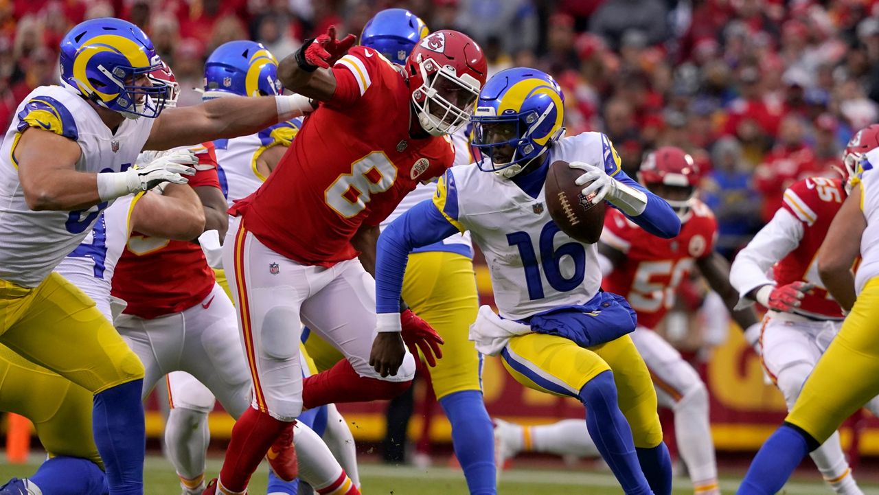 Los Angeles Rams quarterback Bryce Perkins (16) runs from Kansas City Chiefs defensive end Carlos Dunlap (8) during the first half of an NFL football game Sunday, Nov. 27, 2022, in Kansas City, Mo. (AP Photo/Ed Zurga)