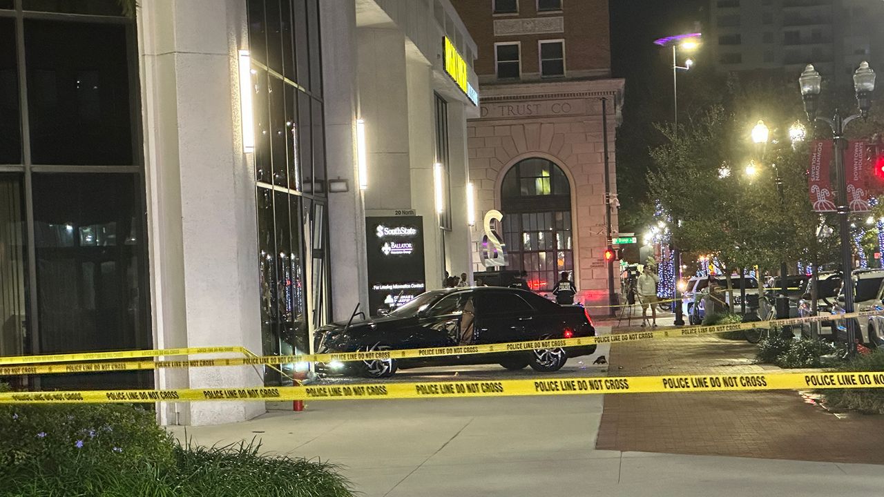 A car crashed into the side of a building near a parking garage where the downtown Orlando shooting occurred. Police have not said how the car is related to the incident. (Spectrum News/Destiny Wiggins)