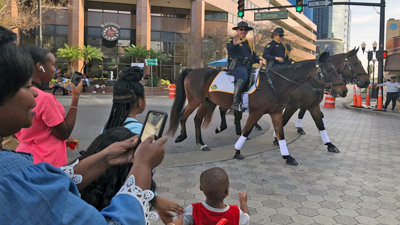 A little boy waves at a law enforcement officer on horseback during the 36 annual Orlando MLK Parade on Saturday, January 18, 2020. (Rachael Krause/Spectrum News 13)