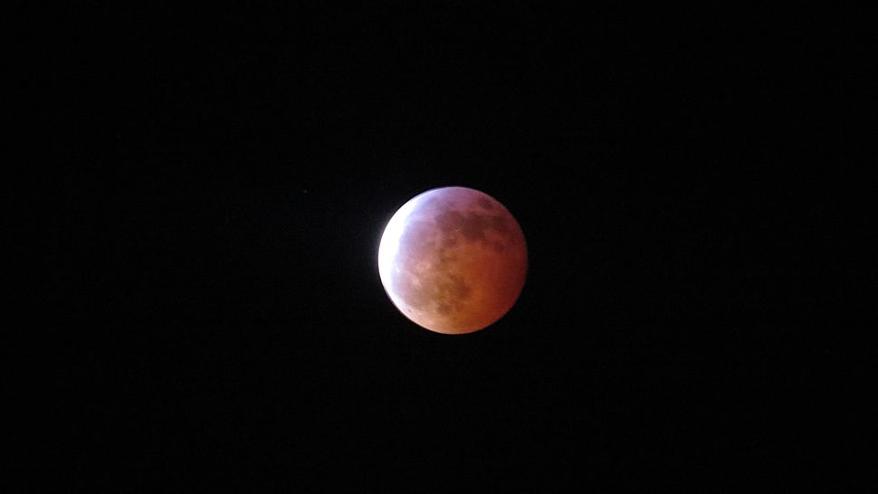 A "super blood wolf moon" begins to enter totality over Florida on Sunday night. (Anthony Leone/Spectrum News)