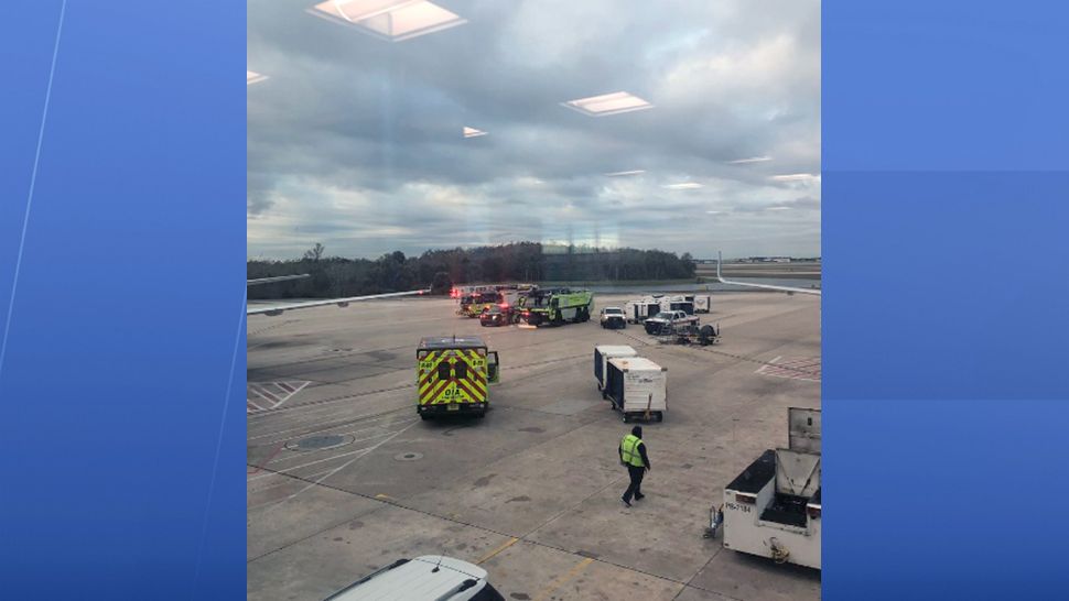 Emergency workers meet a JetBlue plane shortly after it returned to Orlando International Airport on Wednesday. Fumes were reported in the cockpit. (Courtesy of Glenton Gilzean)