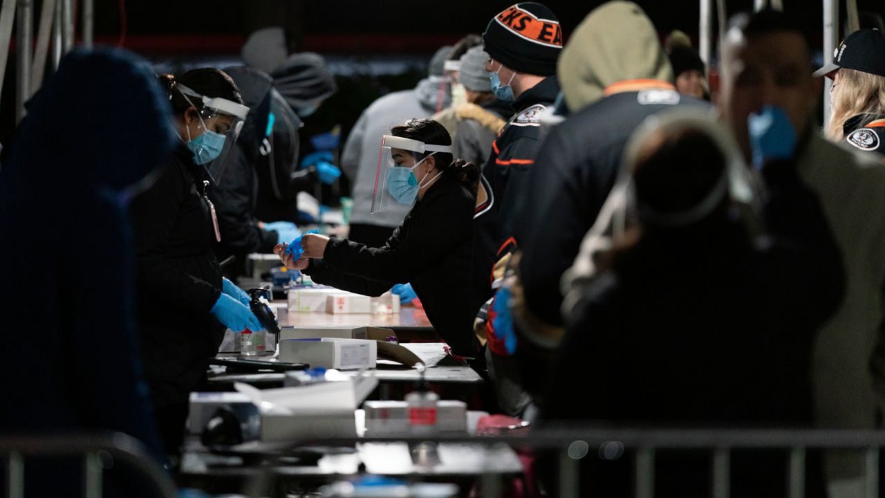 Fans take a COVID-19 test in the parking lot of the Honda Center before an NHL hockey game between the Anaheim Ducks and the Vancouver Canucks Wednesday, Dec. 29, 2021, in Anaheim, Calif. (AP Photo/Jae C. Hong)