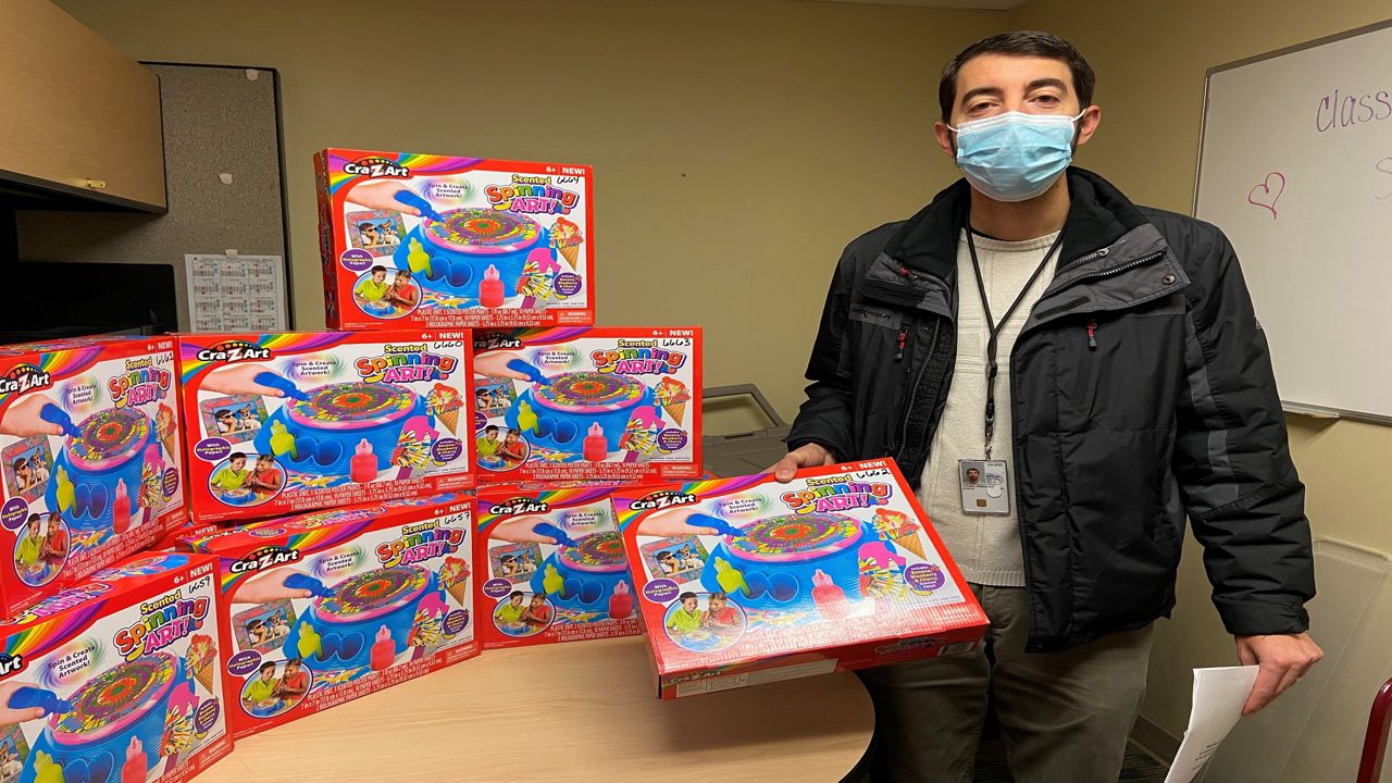 A man poses with multiple art supply toys
