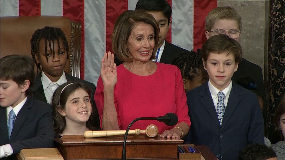 Rep. Nancy Pelosi, surrounded by the children of Congress members, is sworn in as House Speaker. (Spectrum News)