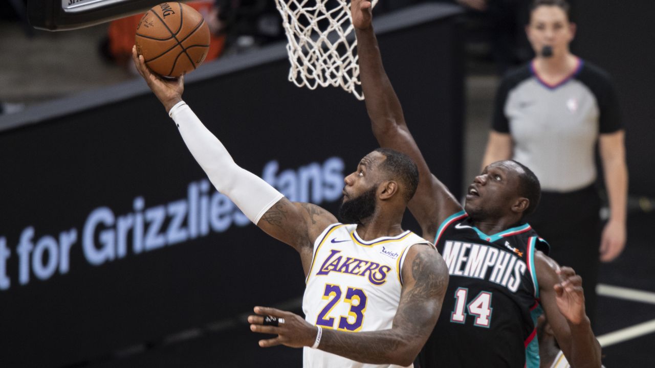 Los Angeles Lakers forward LeBron James (23) shoots past Memphis Grizzlies center Gorgui Dieng (14) during the first half of an NBA basketball game Sunday, Jan. 3, 2021, in Memphis, Tenn. (AP Photo/Wade Payne)