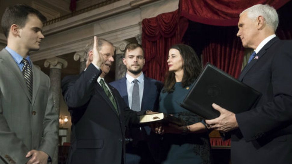 Vice President Mike Pence, right, administers the Senate oath of office during a mock swearing in ceremony in the Old Senate Chamber to Sen. Doug Jones, D-Ala., second from left, with his wife Louise Jones, second from right, Wednesday, Jan. 3, 2018 on Capitol Hill in Washington. (AP Photo/J. Scott Applewhite)