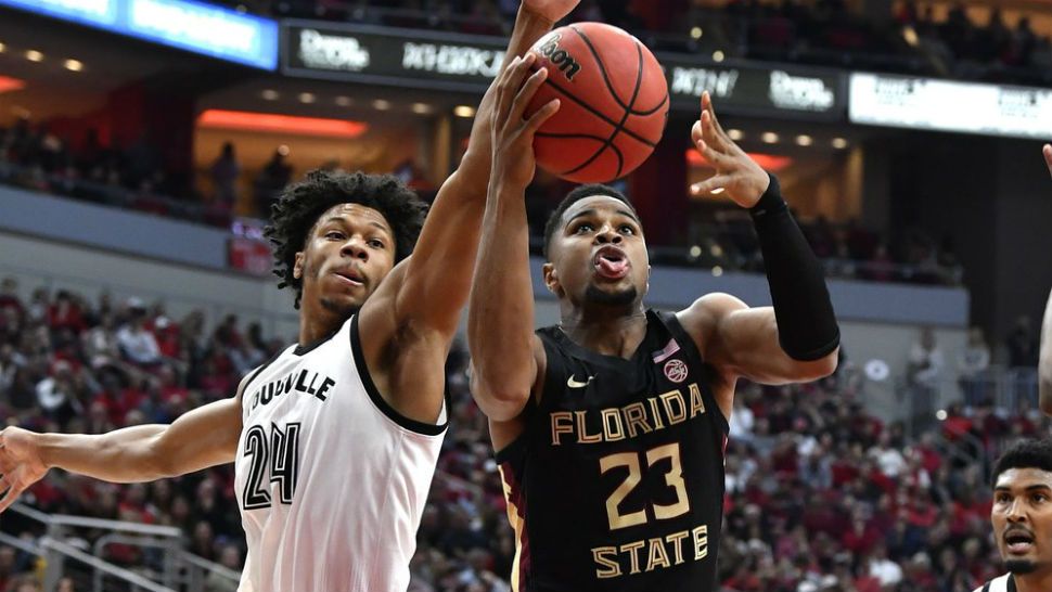 Florida State guard M.J. Walker (23) attempts to shoot past the defense of Louisville forward Dwayne Sutton (24) during the first half of an NCAA college basketball game in Louisville, Ky., Saturday, Jan. 4, 2020. (AP Photo/Timothy D. Easley)