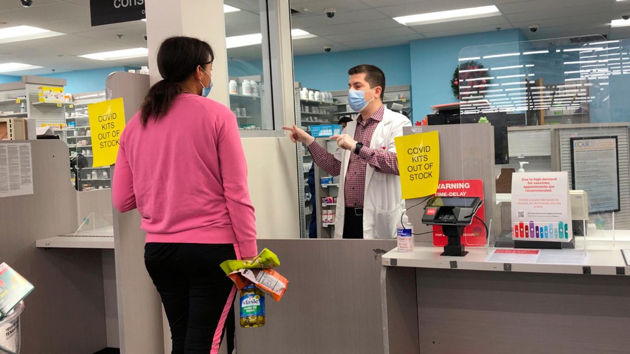 A woman waits at the pharmacy counter at a CVS on Sunset Boulevard in the Echo Park neighborhood of Los Angeles where the location is sold out of CIOVID at-home, rapid test kits during the omicron surge on Tuesday, Jan. 4, 2021. (AP Photos/Stefanie Dazio)