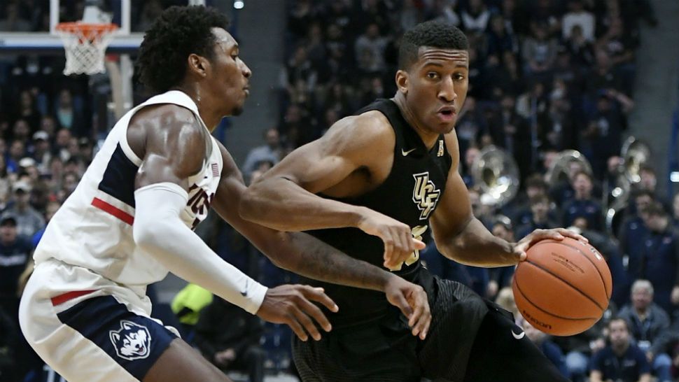 UCF's Aubrey Dawkins dribbles as Connecticut's Christian Vital, left, defends during the first half of an NCAA college basketball game, Saturday, Jan. 5, 2019, in Hartford, Conn. (AP Photo/Jessica Hill)