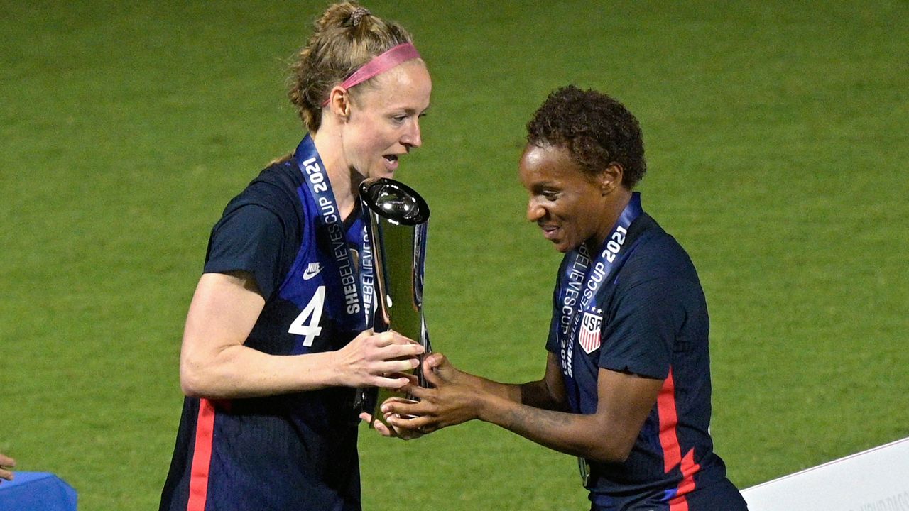 United States defenders Becky Sauerbrunn (4) and Crystal Dunn (19) hold the championship trophy after a SheBelieves Cup women's soccer match against Argentina, Wednesday, Feb. 24, 2021, in Orlando, Fla. (AP Photo/Phelan M. Ebenhack, File)