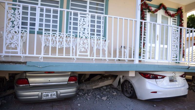 Cars are crushed under a home that collapsed after an earthquake hit Guanica, Puerto Rico, Monday, Jan. 6, 2020. A 5.8-magnitude quake hit Puerto Rico before dawn Monday, unleashing small landslides, causing power outages and severely cracking some homes. There were no immediate reports of casualties. (AP Photo/Carlos Giusti)