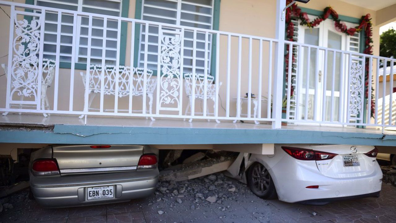 Cars are crushed under a home that collapsed after an earthquake hit Guanica, Puerto Rico, Monday, Jan. 6, 2020. A 5.8-magnitude quake hit Puerto Rico before dawn Monday, unleashing small landslides, causing power outages and severely cracking some homes. There were no immediate reports of casualties. (AP Photo/Carlos Giusti)