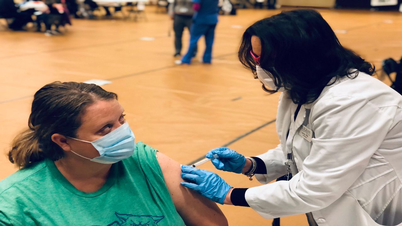 A healthcare worker receives a COVID-19 vaccine at a Lexington clinic.
