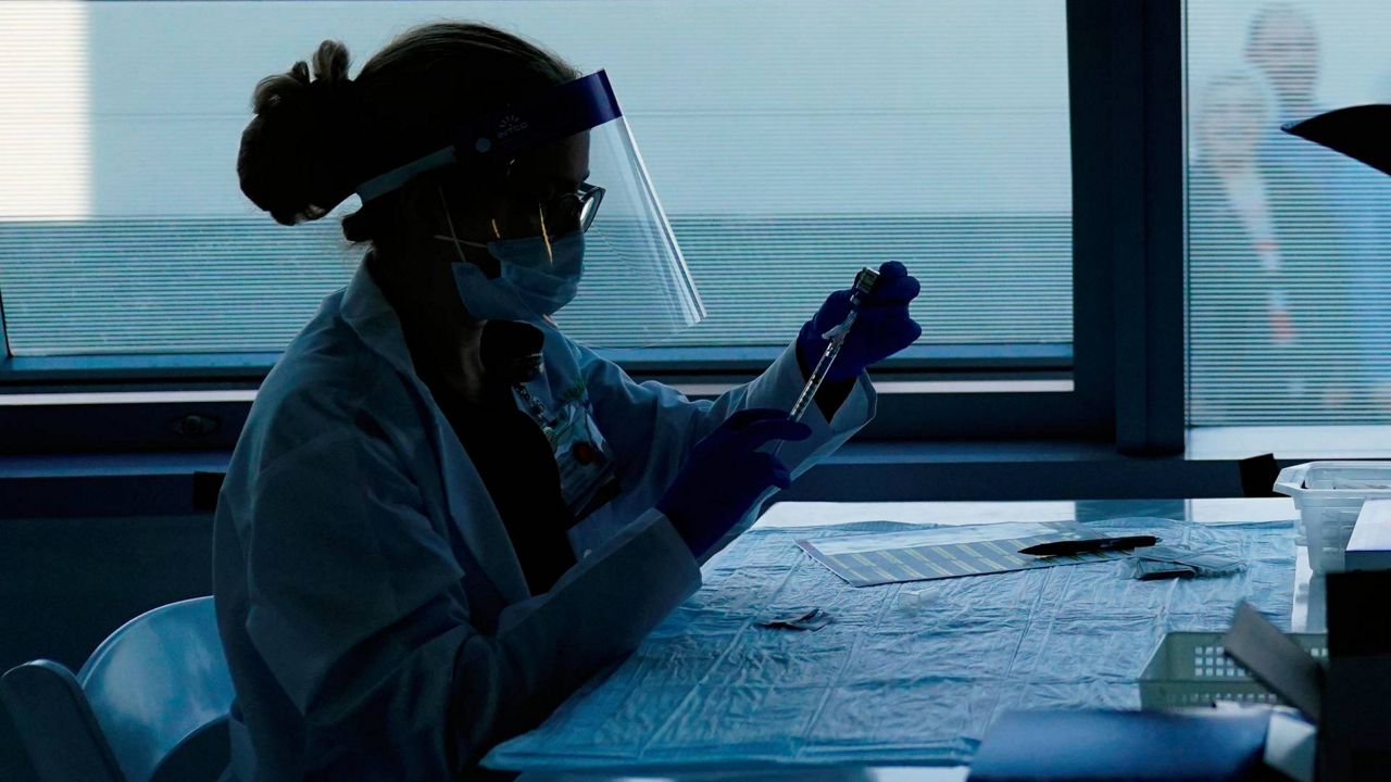 In this Jan. 7, 2021, file photo, a health care worker prepares the Pfizer-BioNTech COVID-19 vaccine for medical workers at a hospital in Orange, Calif. (AP Photo/Jae C. Hong)