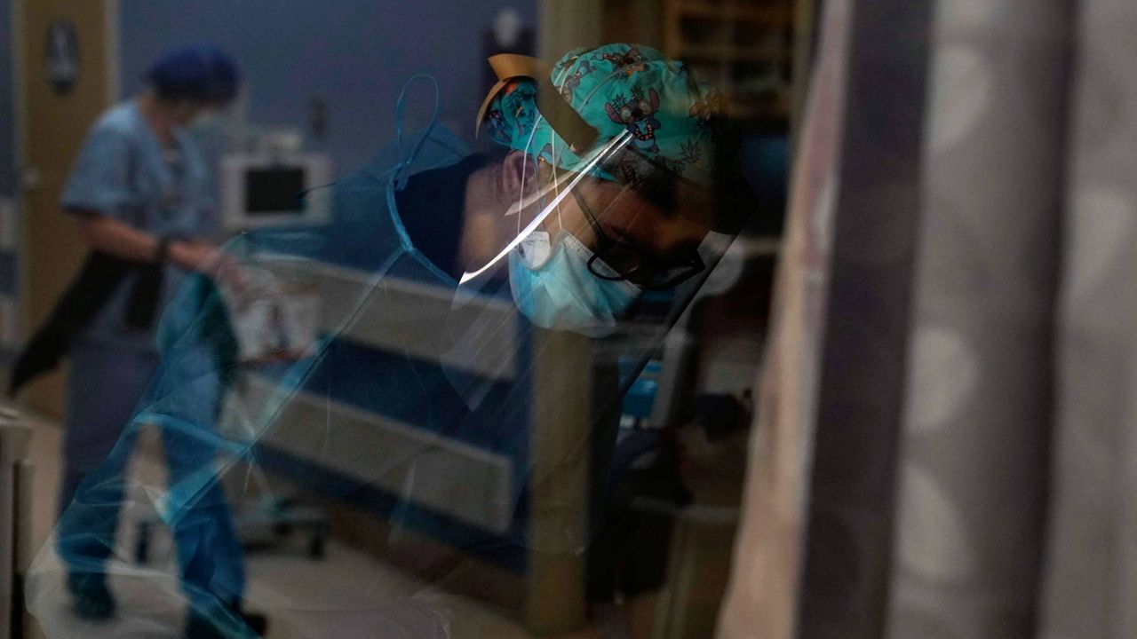 Registered nurse Kyanna Barboza tends to her COVID-19 patient at St. Joseph Hospital in Orange, Calif., Jan. 7, 2021. (AP Photo/Jae C. Hong)