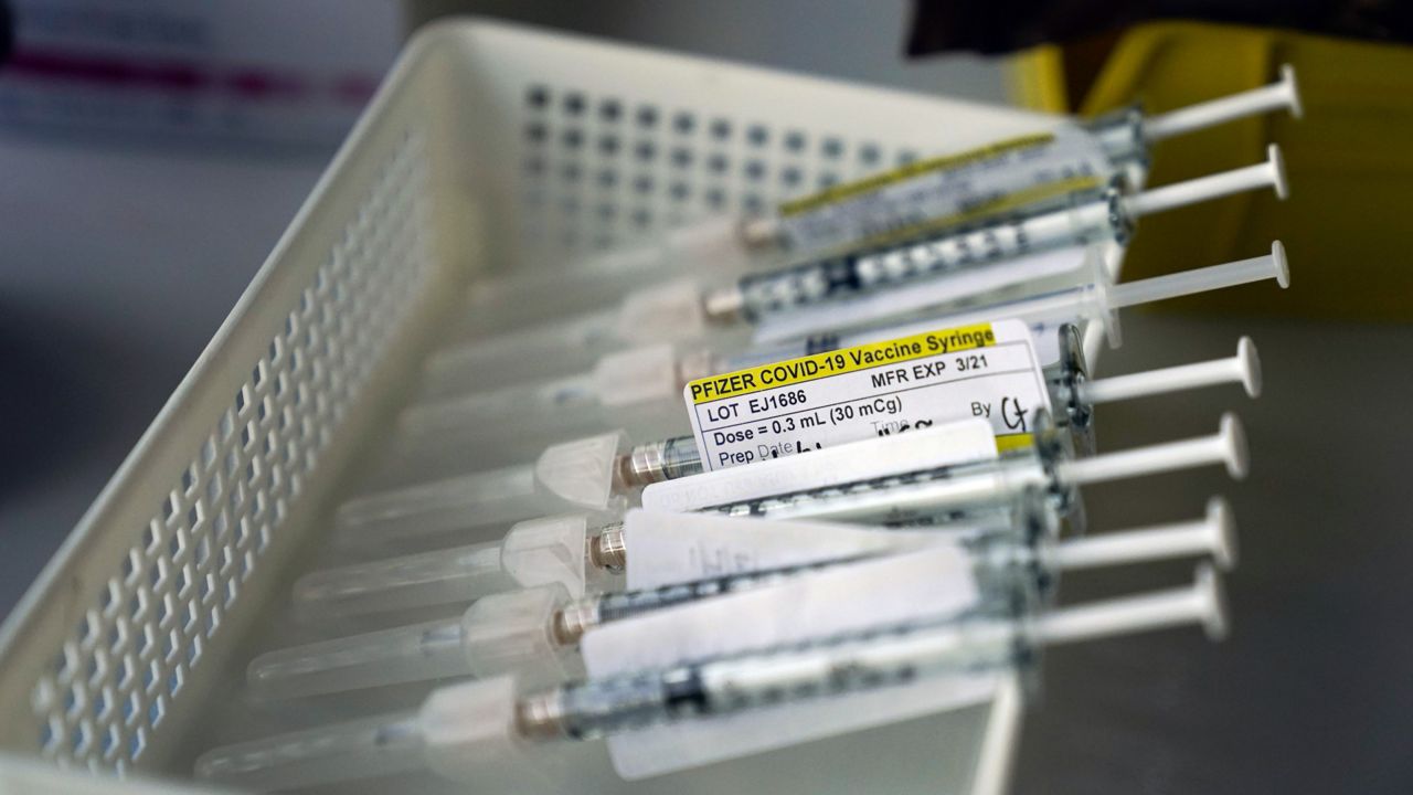 Syringes containing the Pfizer-BioNTech COVID-19 vaccine sit in a tray in a vaccination room at St. Joseph Hospital in Orange, Calif., Thursday, Jan. 7, 2021. (AP Photo/Jae C. Hong)