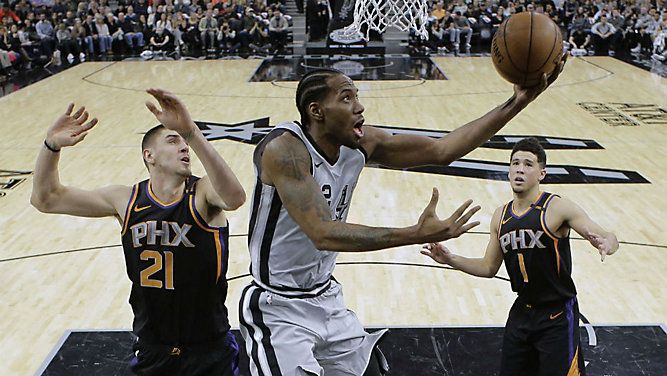 San Antonio Spurs forward (2) scores Phoenix Suns center Alex Len (21) and guard Devin Booker (1) defend during the first half of an NBA game, Jan. 5, 2018. (AP/Eric Gay)