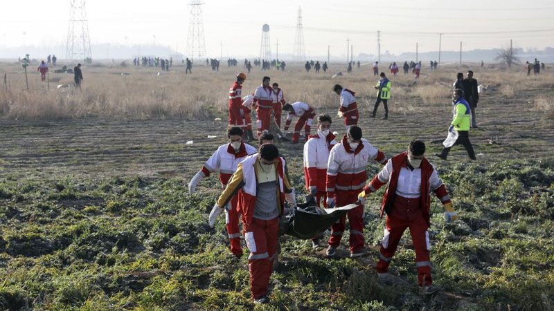 Rescue workers recover the bodies of victims of a Ukrainian plane crash in Shahedshahr, southwest of the capital Tehran, Iran, Wednesday, Jan. 8, 2020. A Ukrainian airplane carrying over 170 people crashed on Wednesday shortly after takeoff from Tehran's main airport, killing all onboard. (AP Photo/Ebrahim Noroozi)