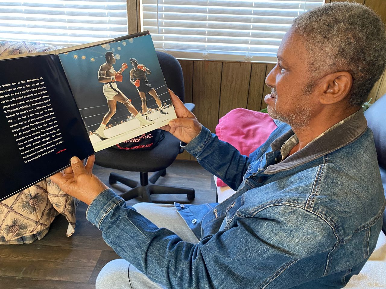Grady Patterson, cousin of heavyweight champion Floyd Patterson, looks over a scrapbook of photos of the boxer.