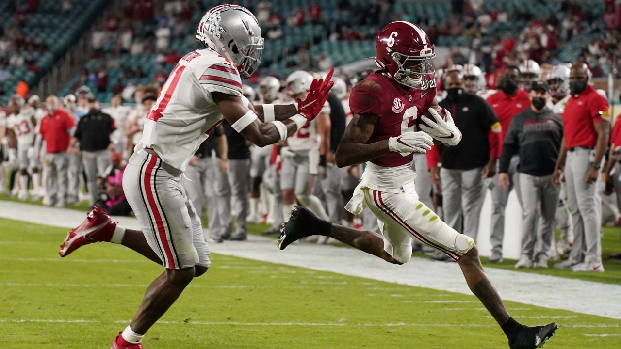 Alabama wide receiver DeVonta Smith scores a touchdown past Ohio State safety Josh Proctor during the first half of an NCAA College Football Playoff national championship game, Monday, Jan. 11, 2021, in Miami Gardens, Fla. (AP Photo/Chris O'Meara)
