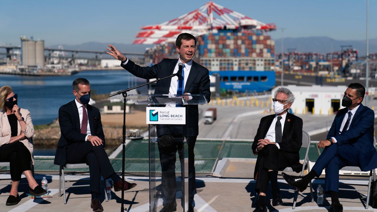 Transportation Secretary Pete Buttigieg, center, speaks during a news conference as he is joined by Los Angeles County Supervisor Janice Hahn, from left, Los Angeles Mayor Eric Garcetti, Rep. Alan Lowenthal, D-Calif., and Long Beach Mayor Robert Garcia at the Port of Long Beach in Long Beach, Calif., Tuesday, Jan. 11, 2022. (AP Photo/Jae C. Hong)
