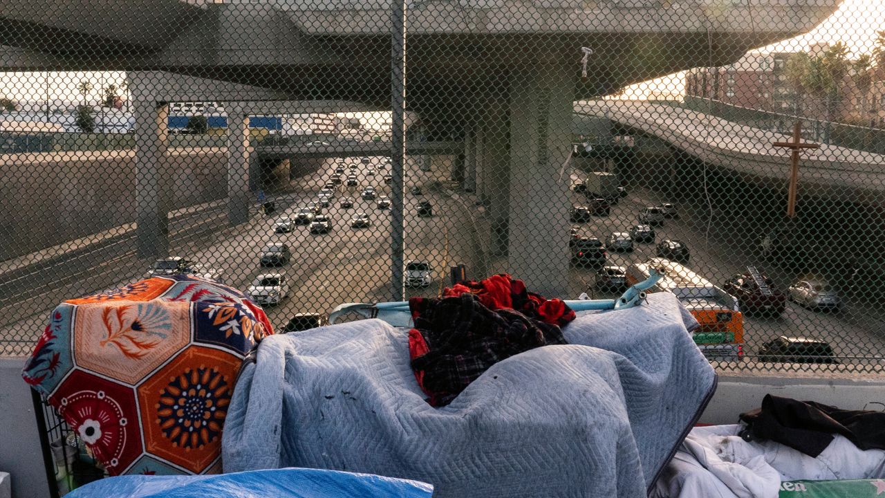 A homeless encampment is seen on a bridge over the CA-110 freeway, Wednesday, Dec. 15, 2021, in Los Angeles. (AP Photo/Damian Dovarganes)